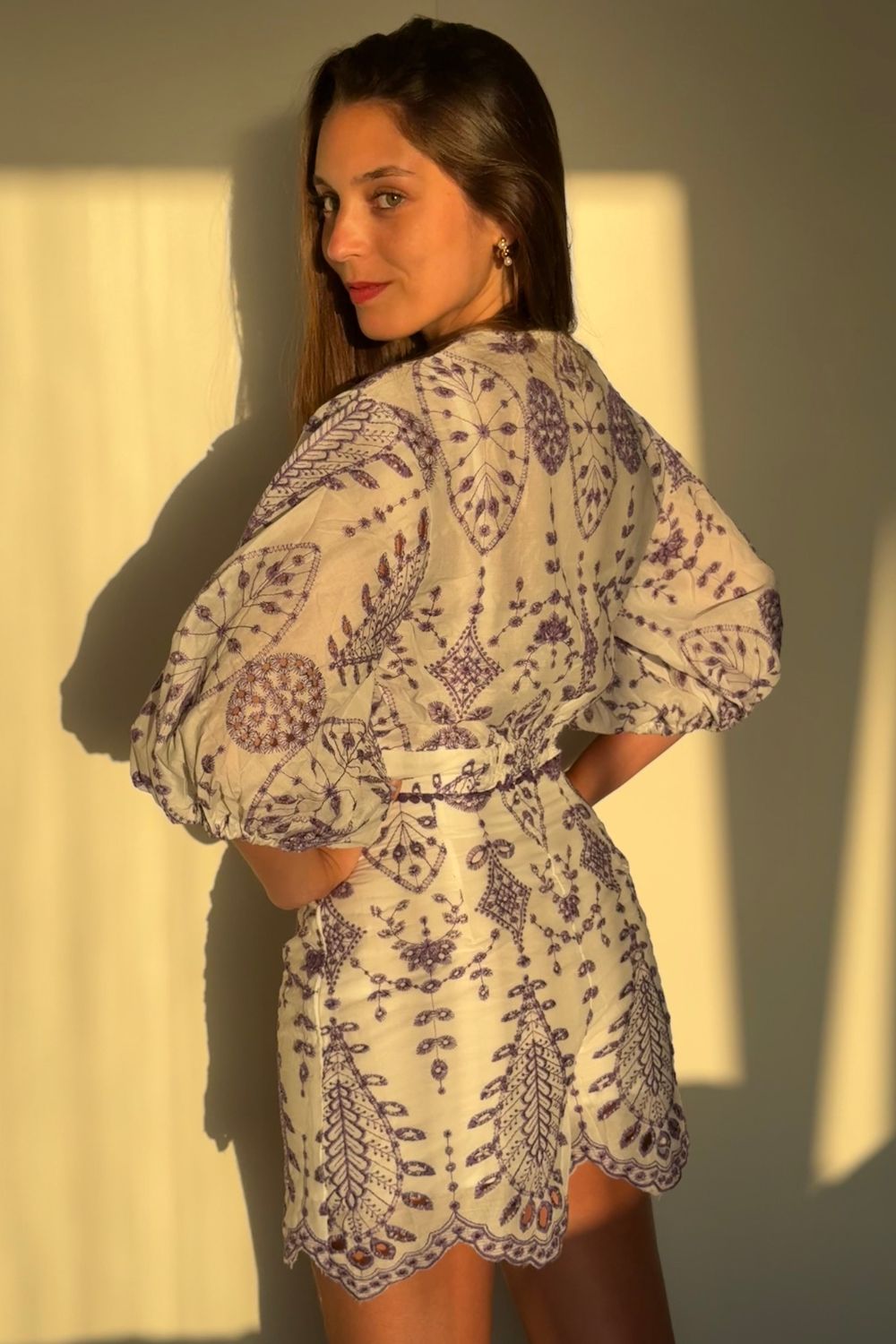 Blusa 3/4 blanca con bordado en todo su diseño. Detalles de flores lilas en la parte inferior y mangas abuchonadas que aportan un toque elegante y femenino. Ideal para cualquier ocasión especial.
